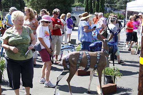 Dozens of people came out to view the painted deers at Forest Lumber Sunday, the only time all 22 deer sculptures were to be together. The Art Alliance of Idyllwild, which has organized this pubic art display, will distribute each sculpture to its personal location throughout town this week.  Photos by Jenny Kirchner