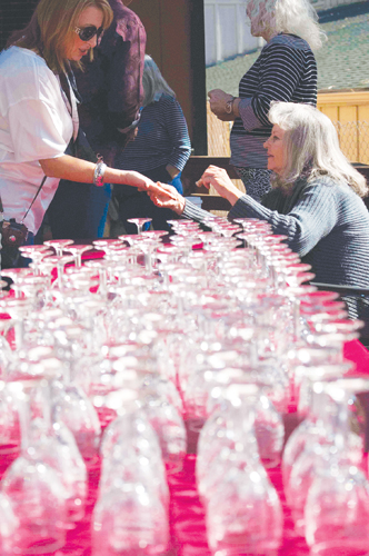 Volunteers ready the wine glasses for the Art Alliance of Idyllwild’s 16th-annual Art Walk and Wine Tasting Saturday afternoon. The wine glass served as a ticket to the popular event.  Photo by John Pacheco