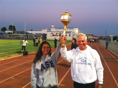 Wes Rizor (right) and the current student body president of Leuzinger High School in Lawndale hold the school’s torch. The school opened in 1931, a year before the Los Angeles Olympics, thus, the Leuzinger “Olympians.” Rizor rededicated the torch just as he did when it was originally dedicated 50 years ago. Photo courtesy of Dawn Sonnier