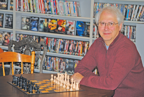 Phil Calderone at the chess board in the Rustic Theatre lobby. Photo by J.P. Crumrine