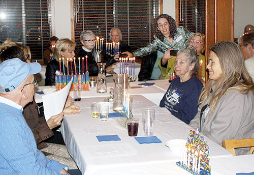  The observance of Hanukkah was true to its name, “The Festival of Lights.” Held on the seventh of the eight-day festival, many participants brought menorahs of many styles — from traditional to ultramodern — to the dinner held Tuesday night at St. Hugh’s Episcopal Church. Photo by Barry Zander
