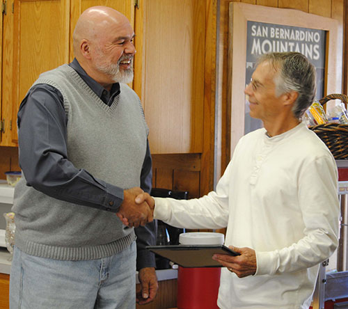 Pine Cove Water District President Mike Esnard (left) presents a certificate of appreciation to Robin Oates of Robin Oates Real Estate for his help representing PCWD in its recent property purchase. Photo by J.P. Crumrine