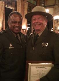 Robert Peek (right) holds his Award of Valor which he received for saving Idyllwild resident Paul Colucci’s life last year. Congratulating Peek is Retired Major General Anthony Jackson, the current director of California’s State Parks. Photo courtesy of Judith Way