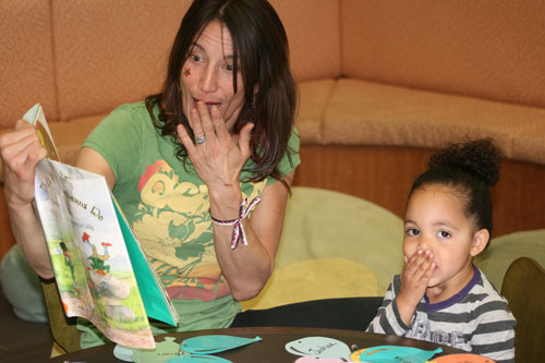Rachael Torrey, Idyllwild Library’s liveliest storyteller, reads a story to 2-year-old Royce Price, who is clearly enjoying her St. Patrick’s Day experience.         Photo by Jay Pentrack 