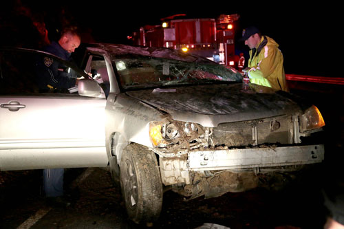 According to CHP Officer Ben Bolon (right), Richard McCleary, 67, of Silverado, was traveling westbound on Highway 74 near mile marker 50 about 7:45 p.m. Friday, Feb. 28, when he lost control and rolled his 2002 Toyota Highlander. American Medical Response transported McCleary, who was complaining of chest pain, to Riverside Regional Medical Center. Bolon and CHP Officer Mike Murawski (left) assess the scene. The cause of the crash is under investigation. Photo by Jenny Kirchner