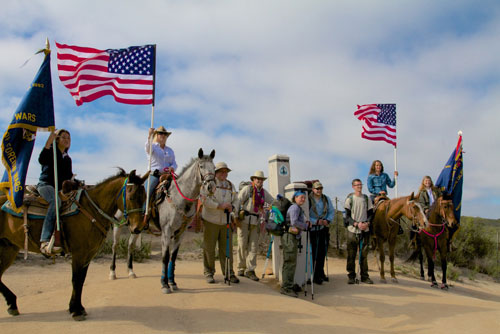 Warrior Hike “Walk Off the War” veterans (in center, from left) Thomas Bielecki, Kevin Black, Angela Powell, Shawn White and Joshua Shields, are seen here on Saturday, April 12, at the start of their Pacific Crest Trail hike in Campo near the Mexican border. The Veterans of Foreign Wars horse escorts the Rambling Roses who gave them a rousing send-off.   Photo courtesy of Sean Gobin