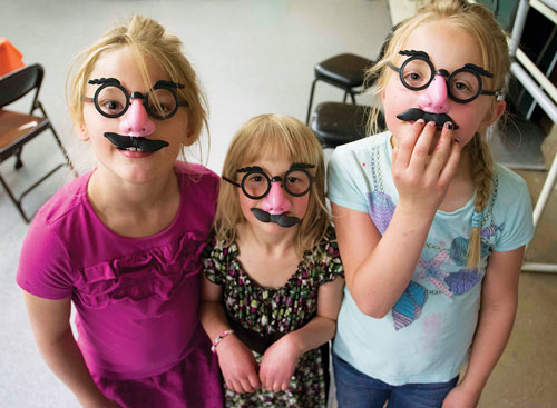 At right, from left, Lily Easley, Emma Isaac and Bailey Easley mug for the camera in masks the Easter Bunny’s helper (his own mask had melted in the car) provided. 