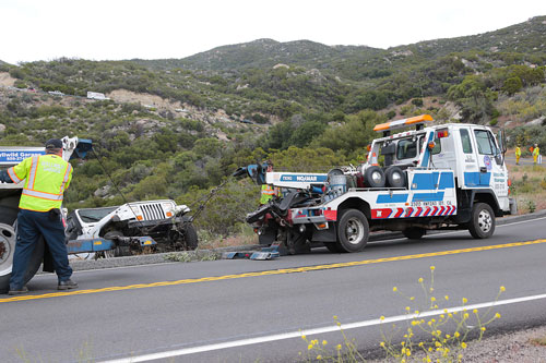 According to California Highway Patrol Officer Chris Blondon, James Sheahan, 53, of Idyllwild, was traveling westbound on Highway 74 last Wednesday when he lost control of his white Jeep Wrangler. The Jeep plunged about 75 feet off the highway landing on its roof. Here, Steve Friemoth (left) and Matt Wheeler from Idyllwild Garage work together to retrieve the Wrangler. The highway was closed in both directions for at least one hour. Photo by Jenny Kirchner