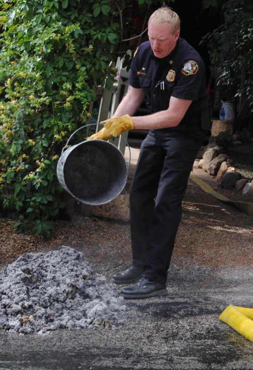 Idyllwild Fire Chief Patrick Reitz brings the smoldering insulation from the house's bathroom to the street.