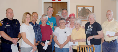 The Pine Cove Property Owners Association gave $7,800 in donations to various local groups at last Saturday’s meeting. Standing, from left, are firefighter Mark Spehar, Pine Cove Station 23; Janice Murasko, ARF; Carl Cripe and Holly Guntermann of the Idyllwild Scholarship Fund; Bill Tell, Radio Amateur Civil Emergency Service (RACES), WNKI and the Mile High Radio Club; Annamarie Padula, PCPOA president; Jerry Holldber, the Woodies; Karen Patterson, the HELP Center; Marge Muir, Tree Lighting Committee; Marlene Pierce, Idyllwild Area Historical Society; and Mike Feyder, Mountain Disaster Preparedness.  Photo by J.P. Crumrine
