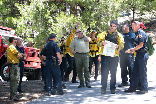 Emergency personnel from Riverside County Fire, the U.S. Forest Service and Idyllwild Fire gather to plan a rescue near the El Guapo Trailhead accessed from Humber Park Sunday afternoon. An adult female climber sustained a fractured ankle and was hoisted by Cal Fire Helicopter 301 and subsequently transported to Keenwild USFS, to be transported to a nearby hospital.  Photo by Jenny Kirchner