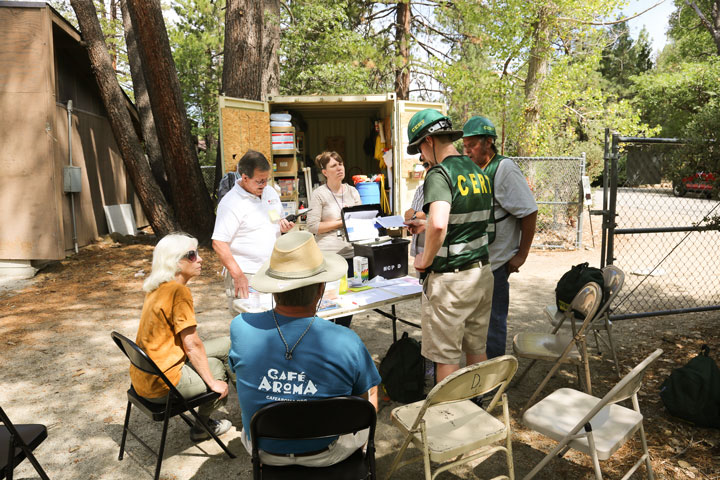Mountain Disaster Preparedness conducted a four-hour “boots on the ground” exercise on Saturday. Here at the Town Hall Disaster Assistance Station, acting group commander Ian Schoenleber (standing center, back to camera) discusses the scenario with fellow team members.           Photo by Cheryl Basye 