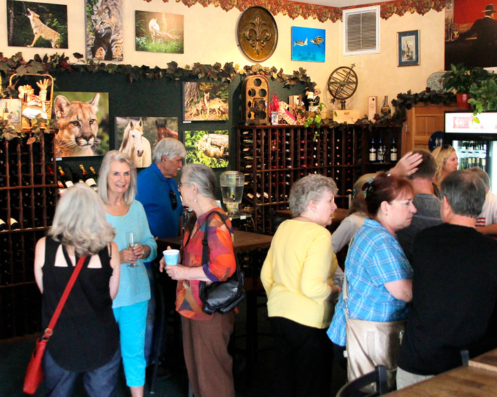 Erin O’Neill and fellow photographer Francoise Frigola enjoy a well-attended opening of O’Neill’s photography exhibit Sunday at Idyll Awhile Wine Shoppe & Bistro. Photo by John Drake