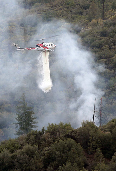 Cal Fire Helicopter 301 drops water on a small lightning fire on Thomas Mountain late Sunday afternoon. Responding units from the U.S. Forest Service and Cal Fire contained the 10-foot by 10-foot fire.       Photo by Jenny Kirchner