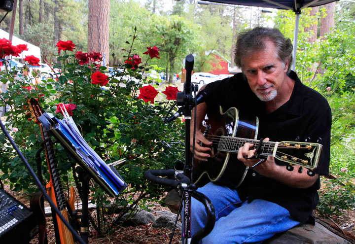 Local musician Jac Jacaruso plays among the roses at the Idyllwild Area Historical Society Museum during the highly popular Idyllwild Home Tour. Photo by John Drake