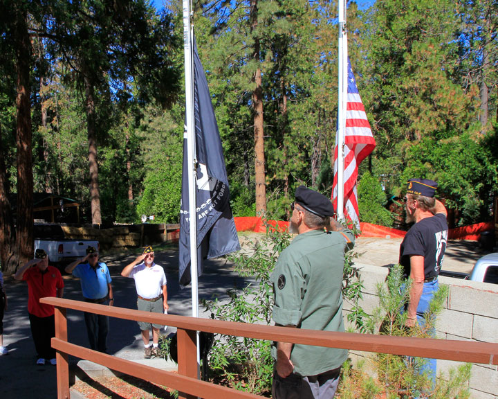 POW SALUTE: Master Sgt. Danny Richardson (lower left), Specialist 4th Class Joe Neu and Warrant Officer David Fraser salute as the colors are lowered to half mast by Master Sgt. Draper (center) and U.S. Marine (ret.) Fred Maholland (right) in remembrance of American POWs and MIAs. This was the first ceremony held by the American Legion Post 800 for this national day of remembrance on the third Friday of September. Photo by John Drake