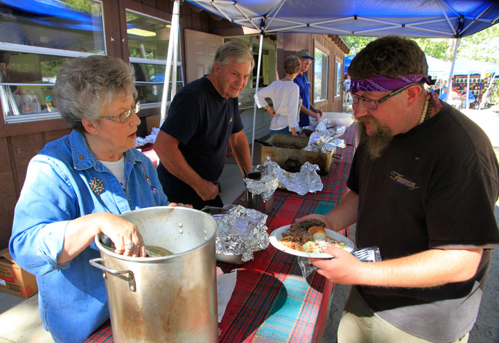 Kate Wanner serves Paul Hamilton his barbecue at Sunday’s Rotary Club barbecue. Photo by John Drake