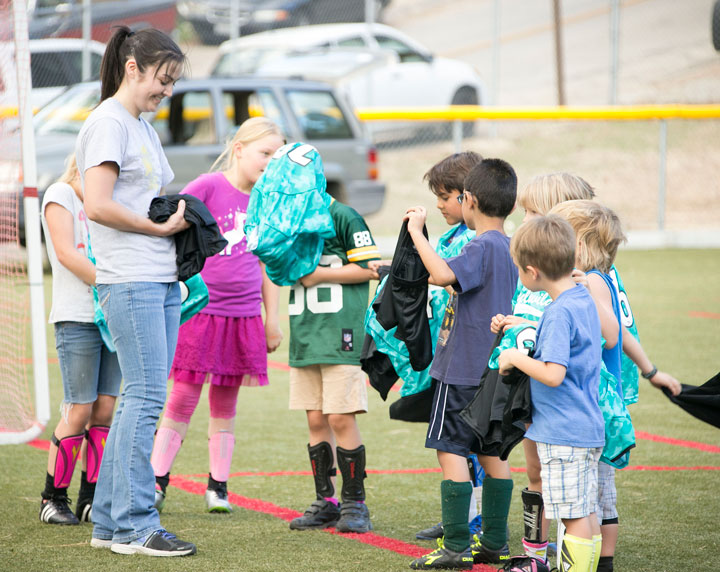 Heather Solorio passes out the jerseys to her team during Monday’s soccer practice.  Photo by Jenny Kirchner