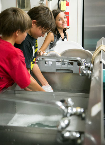 HAPPY HELPERS: Joey and Max Neu with Grace McKimson help wash dishes during the Idyllwild School spaghetti dinner at the American Legion Post 800  Saturday evening.   	        	          Photo by Jenny Kirchner