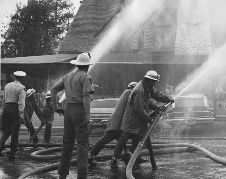 Idyllwild Firemen demonstrate water pressure at Fern Valley Corners in the early 1960s. The building now houses the Creekstone Inn.             File photo