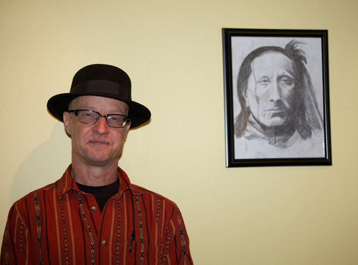 Andrew Jones with his American Indian drawings on exhibit at the Town Baker last Saturday during an artist reception.         Photo by Gina Genis 