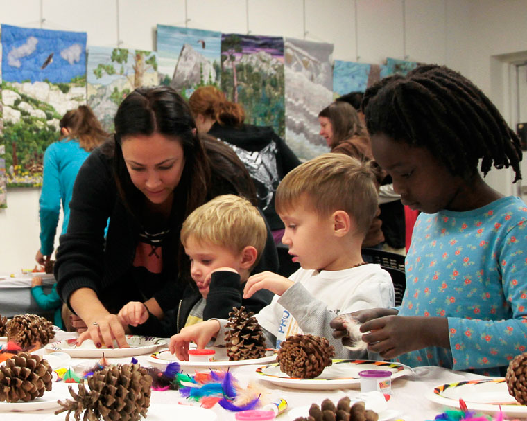 TURKEY TALES: Crystal McCaughey (left) helps Noah and Micah McCaughey and Amelie Peebles turn their pine cones into turkeys during a field trip to the Idyllwild Library’s event: Storytime. This week’s theme was “Turkey Tales” and featured Turkey-related stories as well.     Photo by John Drake