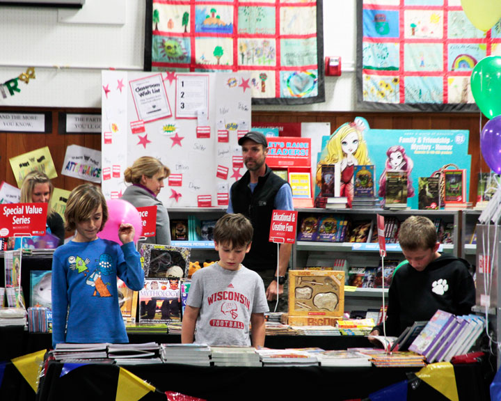 BOOK FAIR:  Brighten Millhouse (left) with friends Fin Carpenter (center) and Joel White (right) take in the wide variety of books available at the Idyllwild School Book Fair last week. Photo by John Drake
