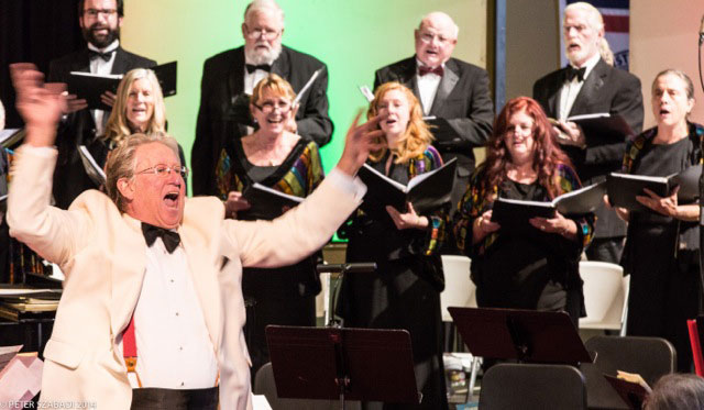 MASTER CHORALE: Dwight “Buzz” Holmes conducts the Idyllwild Master Chorale in its annual concert at the Idyllwild School gym over the past weekend. The Winter Solstice Celebration combined music and fine art, collaborating for the second year with the Art Alliance of Idyllwild.      Photo by Peter Szabadi