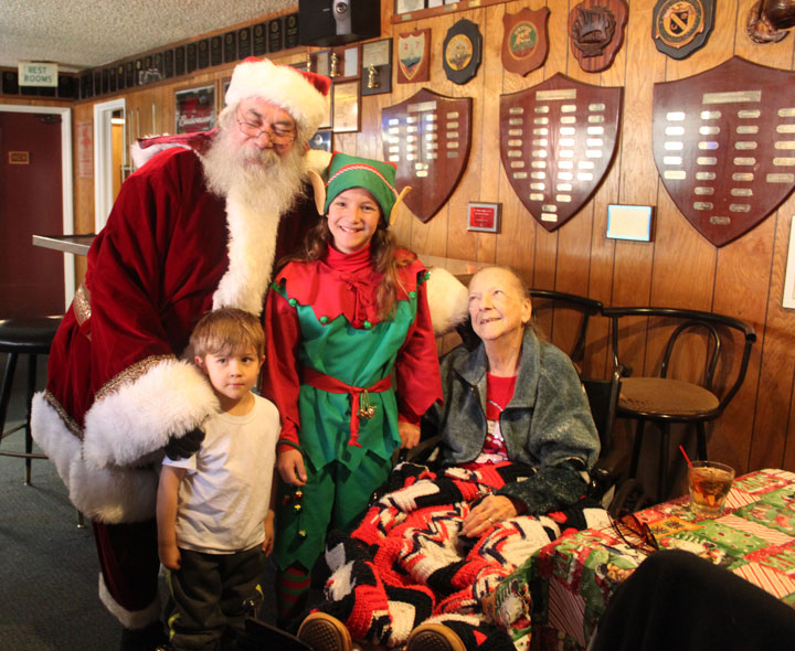 Above, the American Legion Auxiliary hosted its annual holiday Senior Luncheon at noon Sunday at Post 800. Santa (Steve Ward) and an elf (Kylee Ebner) visit with B.J. Ebner (right) and Tayr White during the event. Photo by Genevieve Freeman