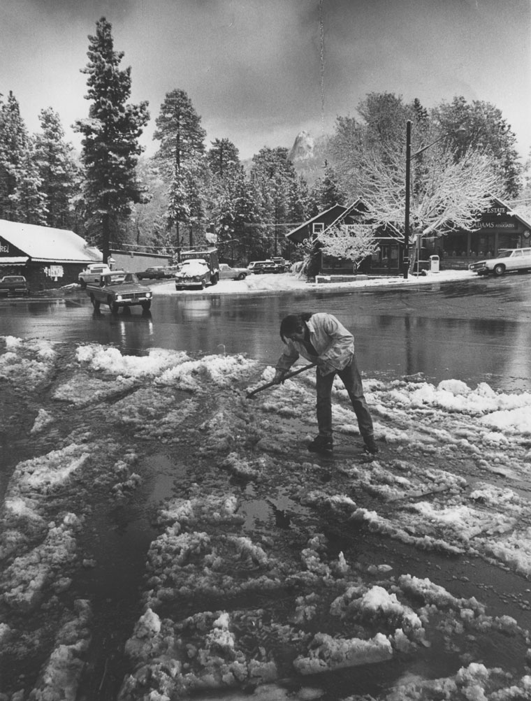 Dan Gallagher shoveled to clear the drive in front of Osuna’s Chevron station as the cloud level lifted above Lily Rock in November 1973.             File Photo/Norwood Hazard 