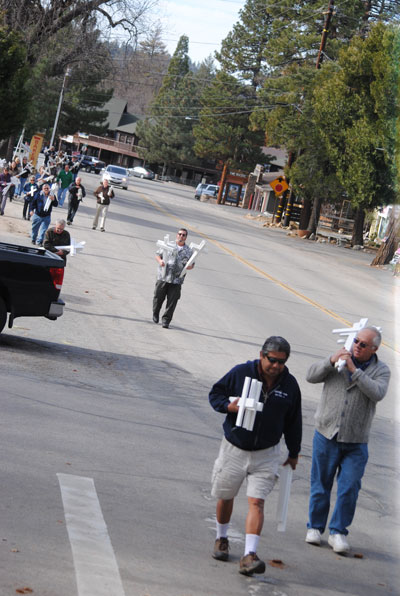 The group walked from the monument to Queen of Angels Catholic Church, the first location of placing 57 crosses. Photo by JP Crumrine