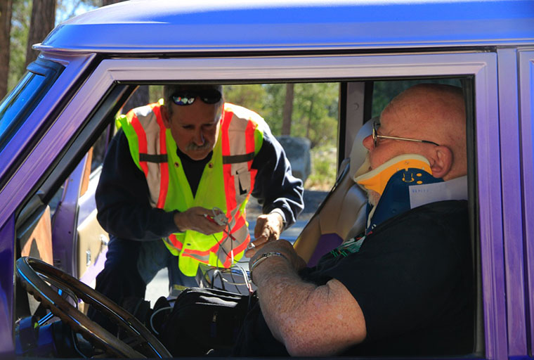 IFPD Jack Peckham checking over Robert Dunn The neck brace was used as a precaution and was later removed. Photo by John Drake