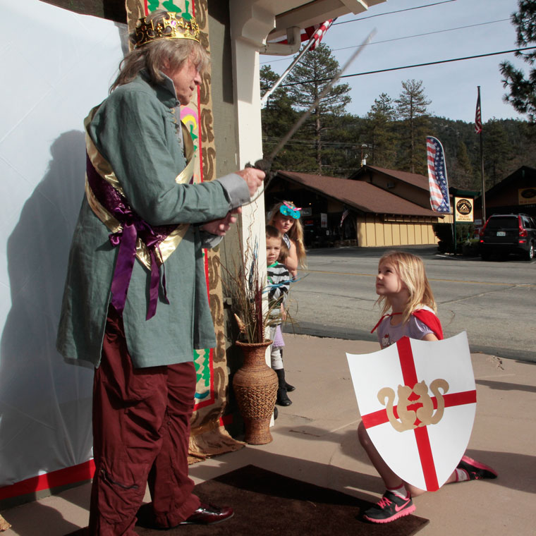 Before seeing “The Sword in the Stone” at the Rustic Theatre Wednesday, Feb. 18, King Darrell Gillett knights Rylan Righetti. Photo by John Drake