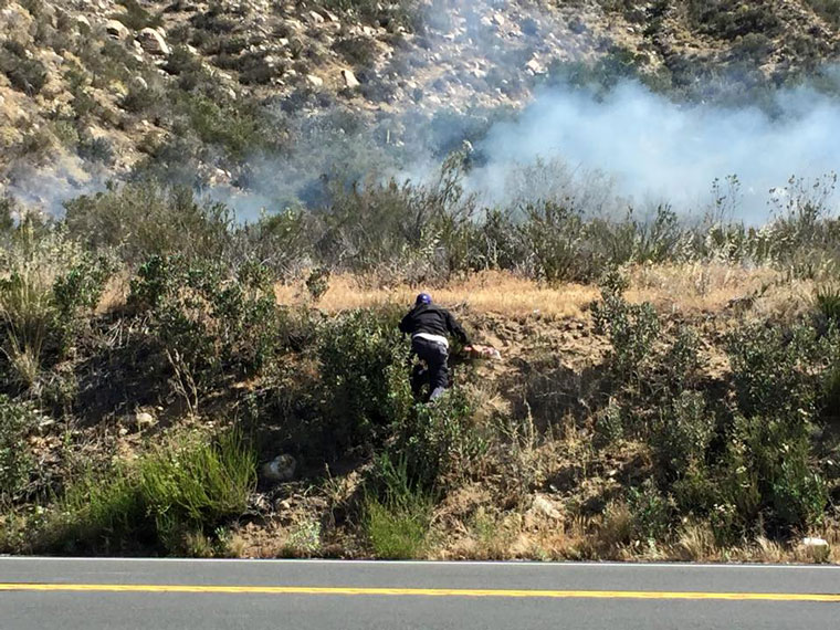 In this photo, Dan Crabtree of Idyllwild Garage is seen climbing up the hillside before attempting to fire-extinguish the Cranston Fire before firefighters arrived on Tuesday, April 7.Photo by Marjie Ibanez 