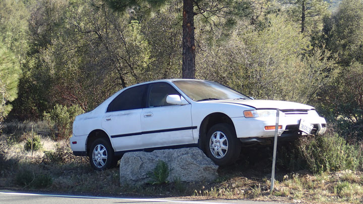 “An interesting parking job,” noted California Highway Patrol Public Information Officer Darren Meyer when shown this photo for identification purposes. Idyllwild Garage towed the car from Highway 243 in Mountain Center near Gibraltar Ranch Monday morning to the owner’s home in Idyllwild after it had come to rest on its rock perch the night before. CHP was not called to respond and no further details were available. Photo by Halie Wilson