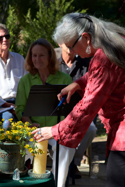 In the garden at Spirit Mountain Retreat and with locals in attendance, Executive Director Mary Morse lights a ceremonial candle to commemorate the spring solstice on Sunday. Photo by John Drake