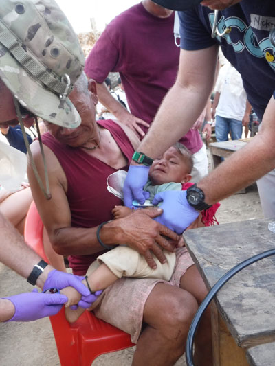 The medical team examines a baby who lost its mother because of the first earthquake. Photo by Matt Jordan