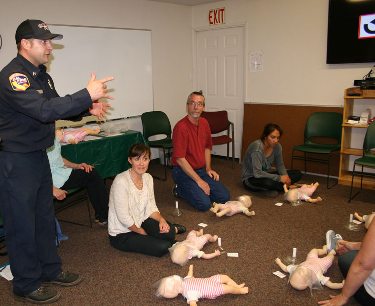 Pine Cove Station 23 Capt. Tim Ellena teaches a free CPR class at the Mountain Resource Center Wednesday evening, May 27. Shown practicing on the floor are, from left, Halie Wilson and Mile High Radio Club President Bill Tell. Riverside County Fire teaches the class in conjunction with the American Heart Association. The free class covers infants to adults and also choking cases.Photo by Becky Clark