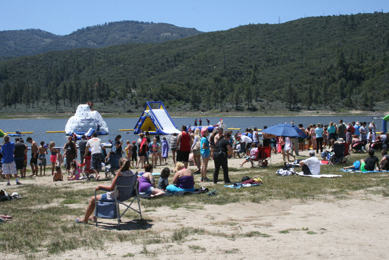 By 12:15 p.m. Saturday, June 6, Lake Hemet Campground officials estimated more than 1,500 people were on site, many of them headed to the new water park. Here people relax on the beach, swimmers enter the water and young enthusiasts play on the water-park structures. Photo by Marshall Smith