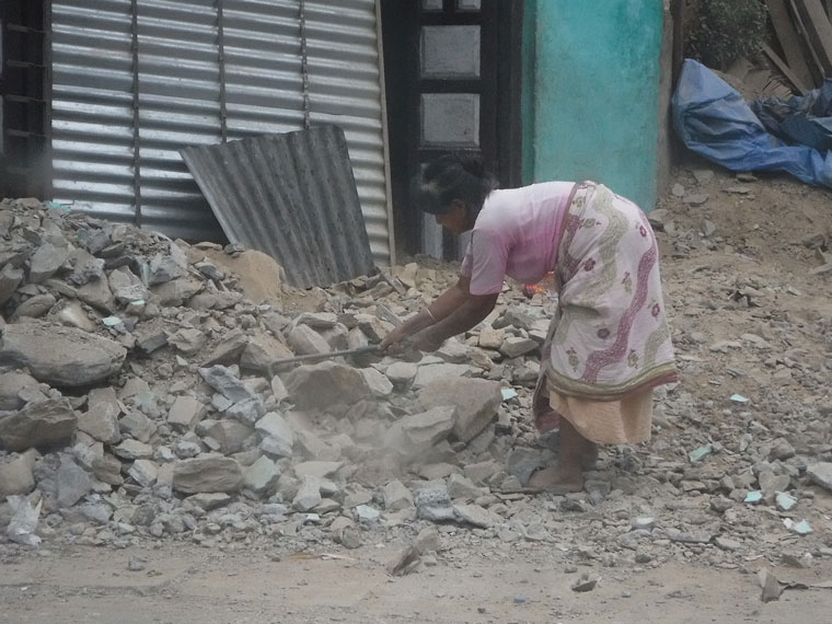 A villager works to clear the debris of her former home after two earthquakes struck Nepal this year.Photo by Matt Jordan 