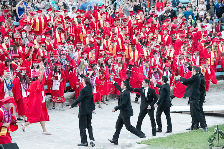Students in the daisy chain rush the 2015 Hemet High graduating class and start a silly string battle at the conclusion of the graduation ceremony at the Ramona Bowl Thursday evening. 