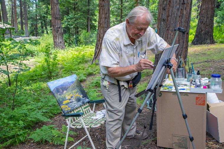 Karlis Dabols works on his second painting of the day near the creek at Wilder Cabins on South Circle on Saturday during the Art Alliance of Idyllwild’s Sizzling Summer Plein Air and Working Artist event. Photo by Jenny Kirchner