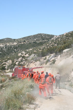 Crews from Oak Glen Conversation Camp, California Department of Corrections and Rehabilitation, feed slash into a chipper on Poppet Flat Trail on Wednesday, June 3, as part of a fuel thinning and shaded fuelbreak project funded by SRA Fire Prevention Fee tax dollars. Photo by Marshall Smith