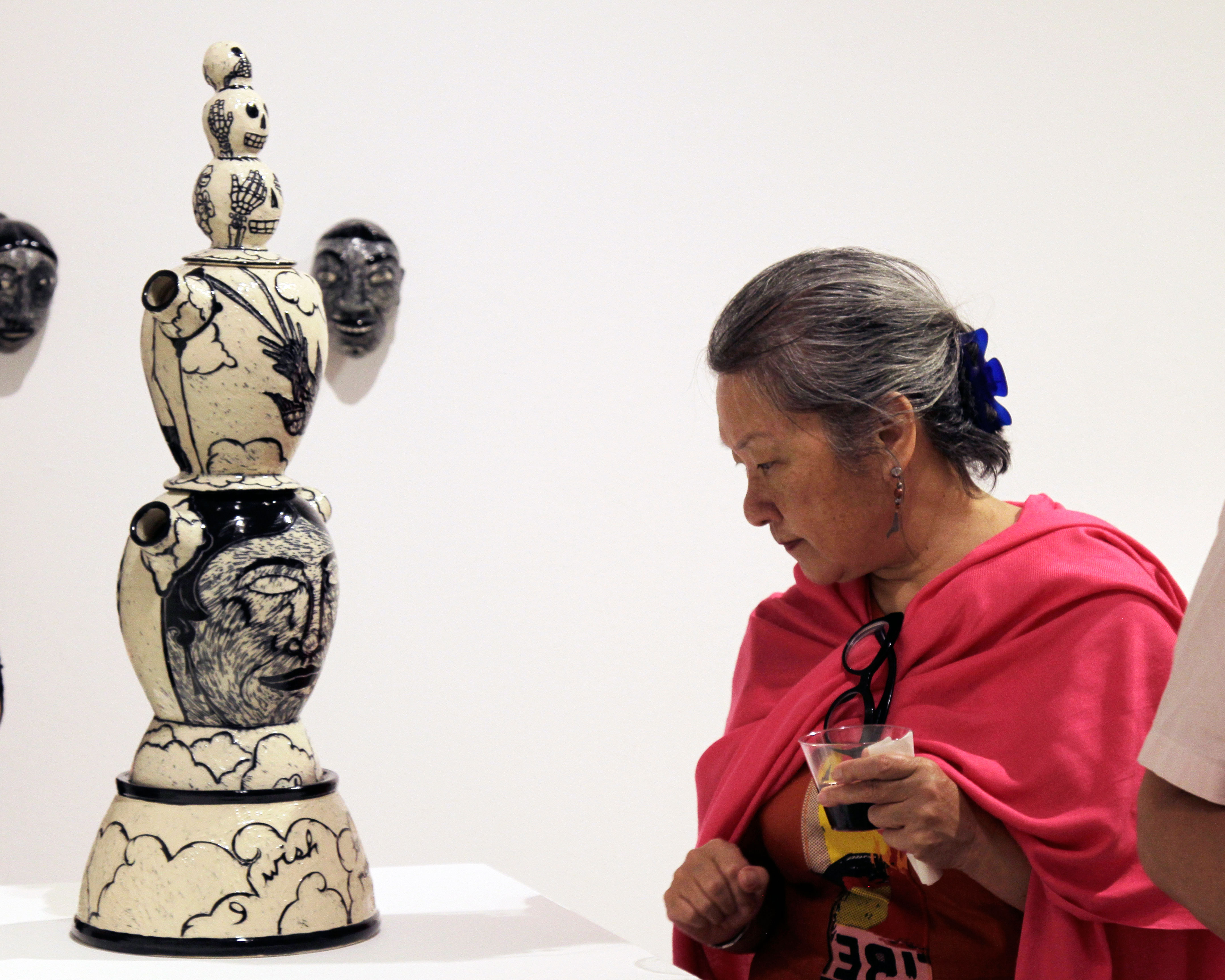 Chinlee Chang, one of the 2015 Idyllwild Arts Summer Programs’ arts students, admires ceramic art from a favorite teacher, Kathy King, at the Parks Exhibition Center’s Monday night opening reception.Photo by John Drake