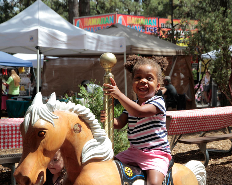 Emmerson Renner enjoys herself on the wooden horses at the Lemon Lily Festival over the weekend.   Photo by John Drake 