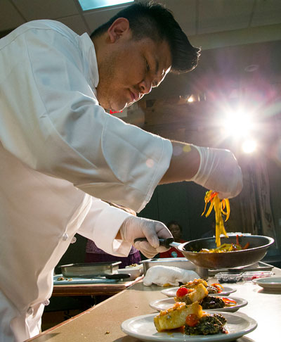 Chef Freddie Bitsoie, from the Navajo tribe, starts plating his entree as time runs out during the Native American Chef Competition Friday night at Idyllwild Arts. Photo by Jenny Kirchner