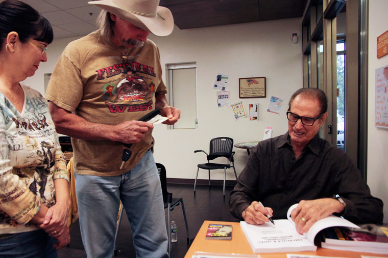 Fan Dan Kirby (center) gets Michael Dante (right) to autograph his book “From Hollywood to Michael Dante Way.” Dante discussed the book Saturday at the Idyllwild Library.Photo by John Drake 