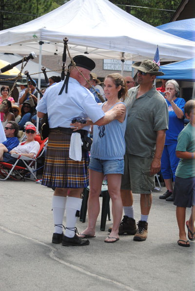 Audrey Stavroplus (center) and husband Lou (right) attended this year’s Fourth of July Parade. Her late father, former Idyllwild Water District President Allan Morphett, arranged for the University of California, Riverside, Bagpipers to be a regular participant in the parade. Here, Audrey hugs Pipe Band leader Mike Terry (left). Photo by J.P. Crumrine