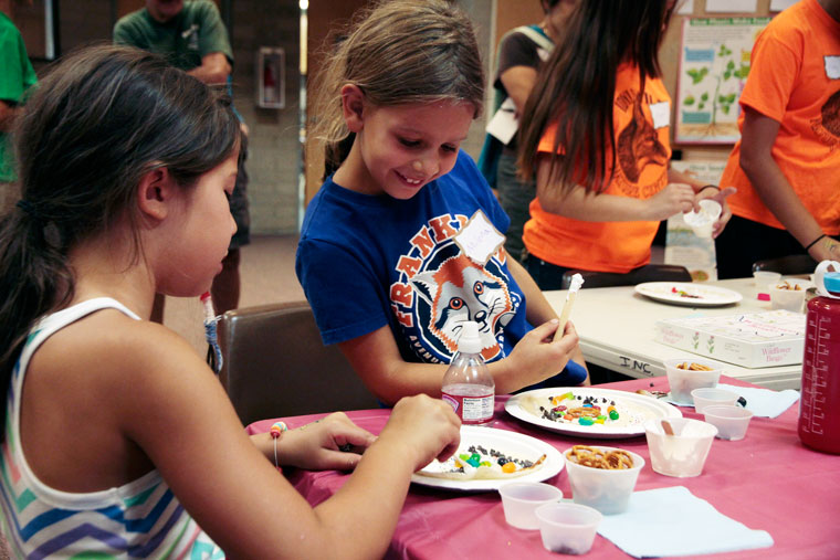 Junior Naturalists: Milena checks out what edible crafts friend Serenity Gay is creating. The Junior Naturalists meeting was themed “Power Plants” and held at the Nature Center on Saturday. Photo by John Drake