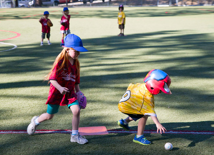 Kaelynn Johnston (left) played first base for the American Legion T-ball team Thursday at Idyllwild School. The Town Baker batter (right) grabs the ball, which he just hit, to give to Kaelynn. Photo by Jenny Kirchner